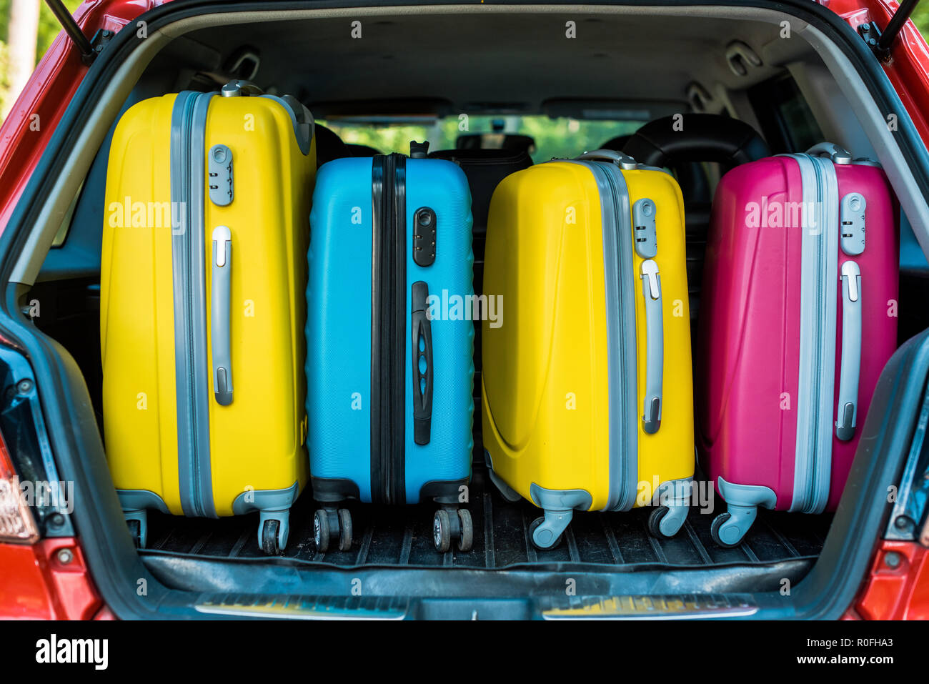 colored travel bags in car trunk Stock Photo Alamy