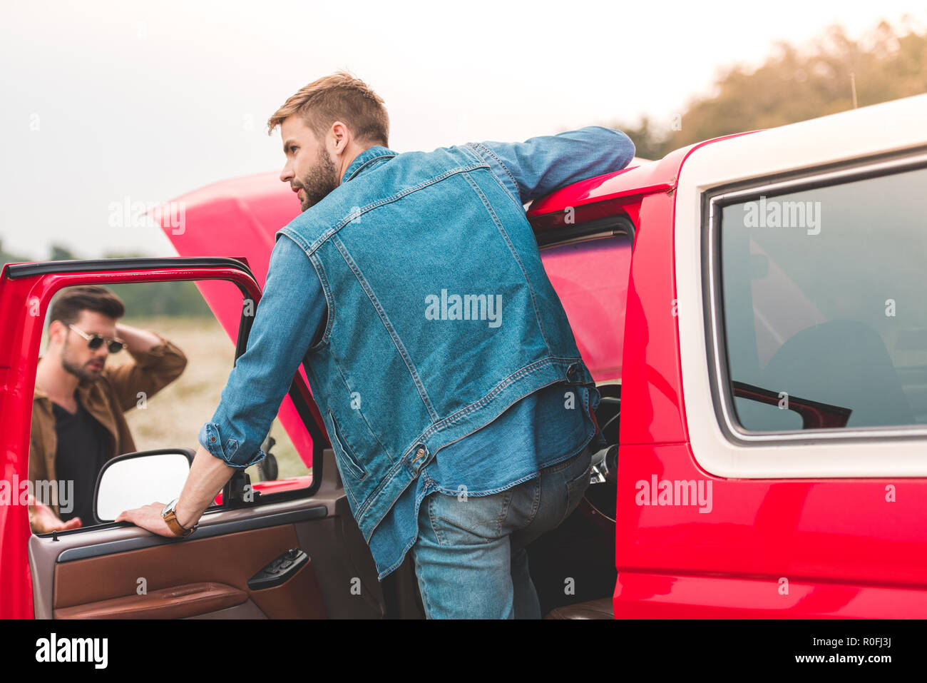 handsome young men with broken car engine in field Stock Photo - Alamy