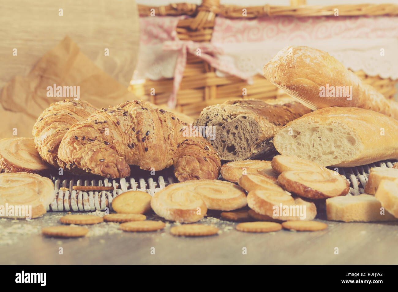 Various bakery and pastry products on rattan mat on wooden table Stock Photo