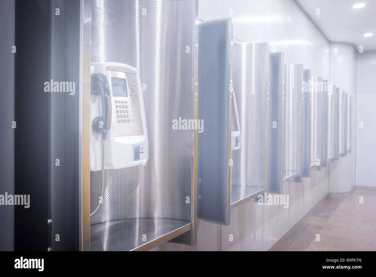 Perspective row of public telephone inside modern building Stock Photo
