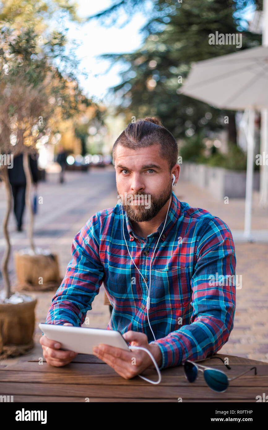 Handsome hipster guy working on digital tablet. Stock Photo