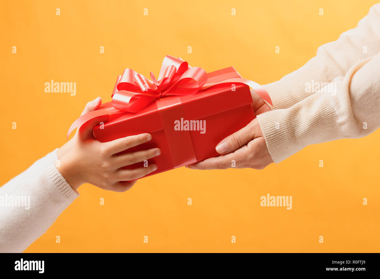 Hands of parent giving a gift to child.The concept of giving and