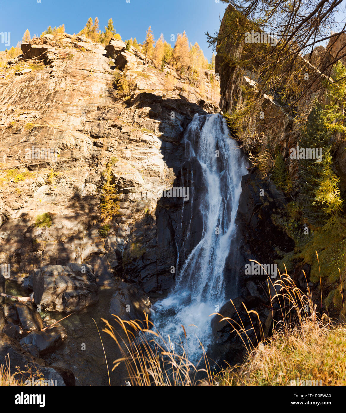 Wonderful waterfall in the forest in the mountains during the autumn season with light and shadows in the undergrowth Stock Photo