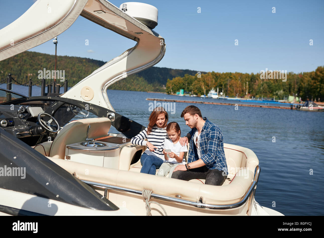 Family with daughter vacation together on sailboat in lake Stock Photo