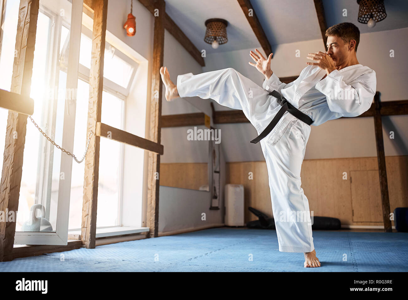 black belt karate fighter training hight kick Stock Photo
