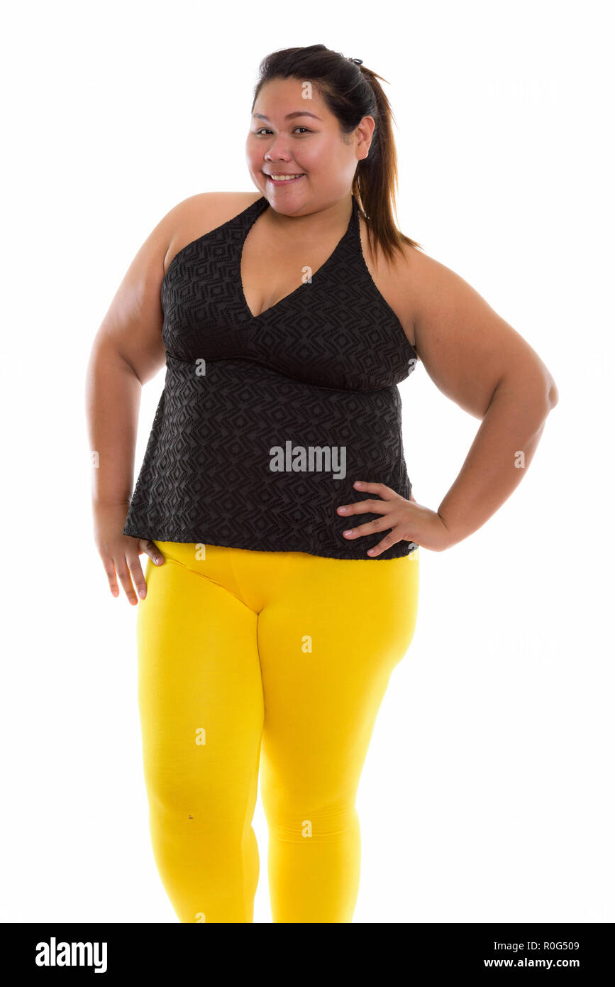 Studio shot of young happy fat Asian woman smiling and standing  Stock Photo