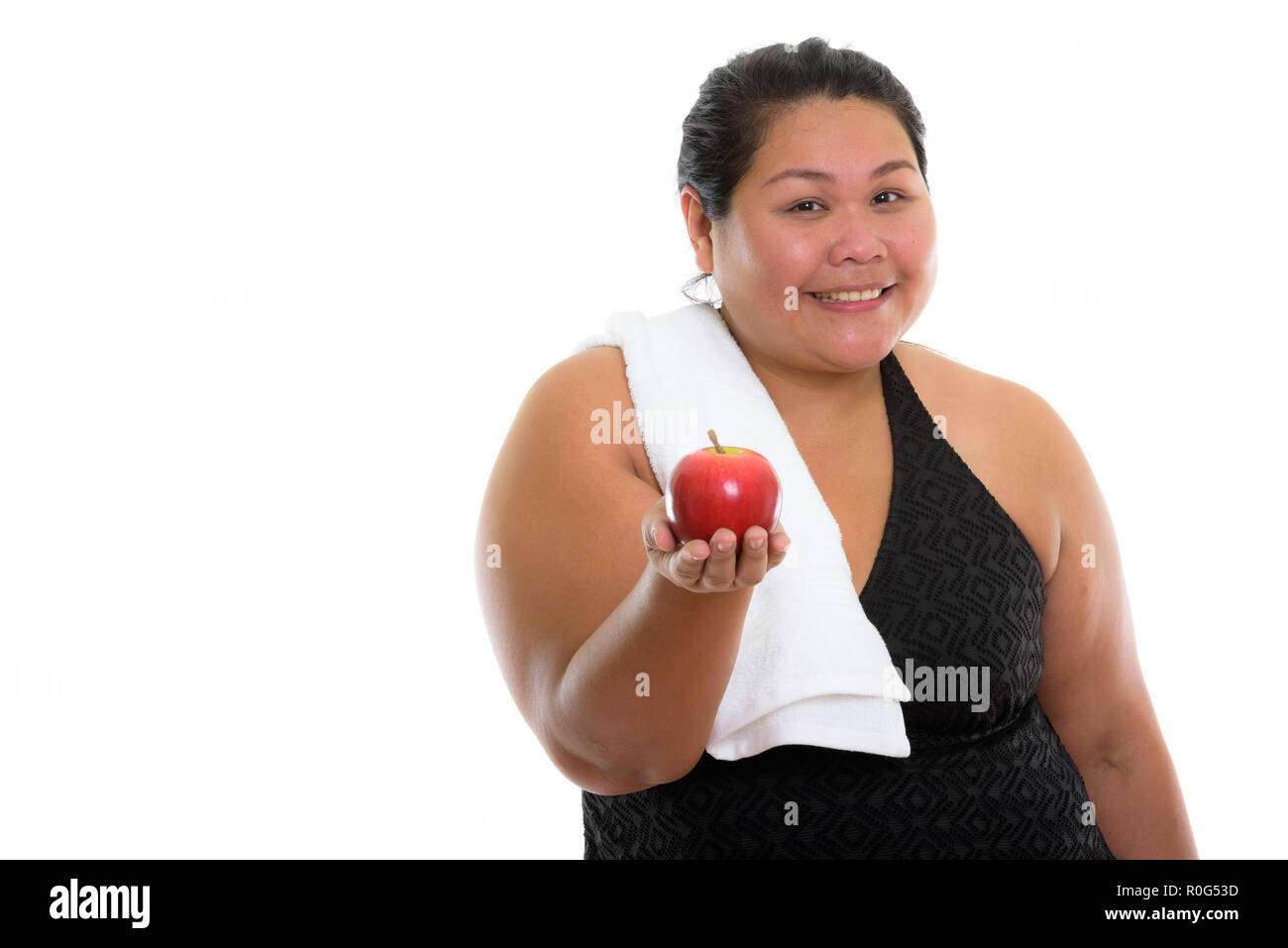 Studio shot of young happy fat Asian woman smiling while giving  Stock Photo