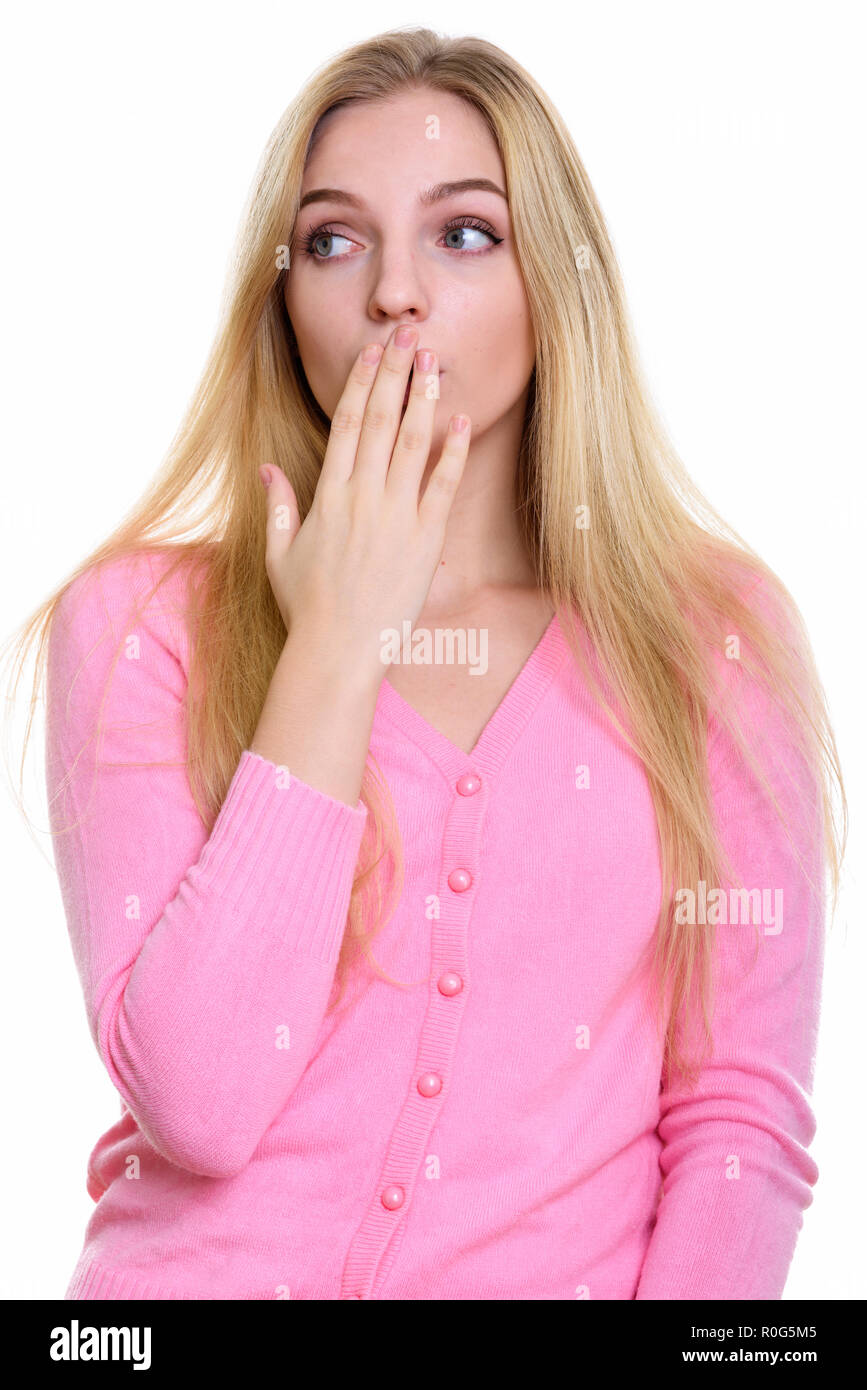Studio shot of young beautiful teenage girl covering mouth while Stock Photo