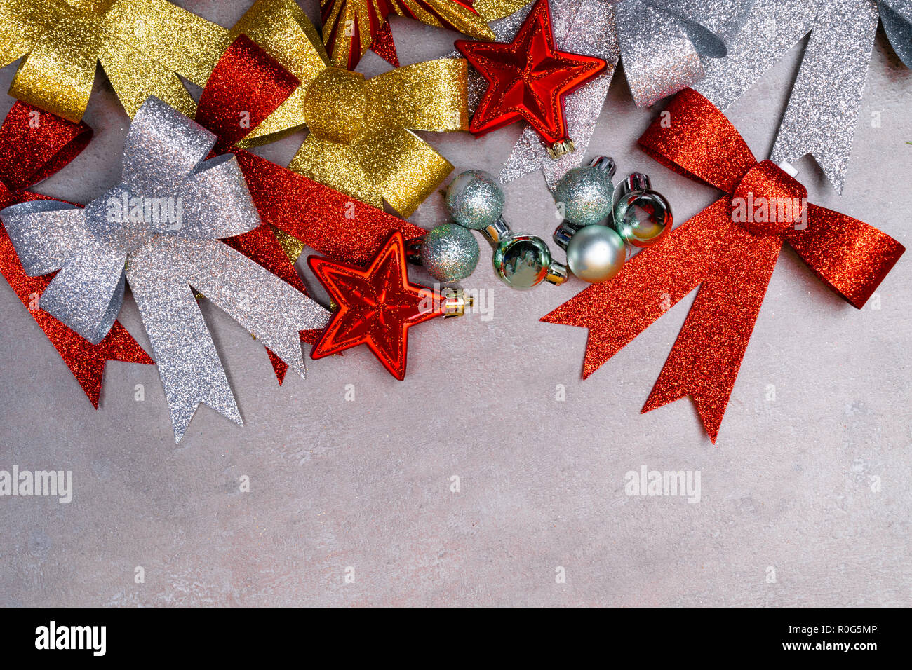 Traditional silver, gold, and red Christmas decorations collection on grey background. Christmas greeting card for the festive season with copy space Stock Photo