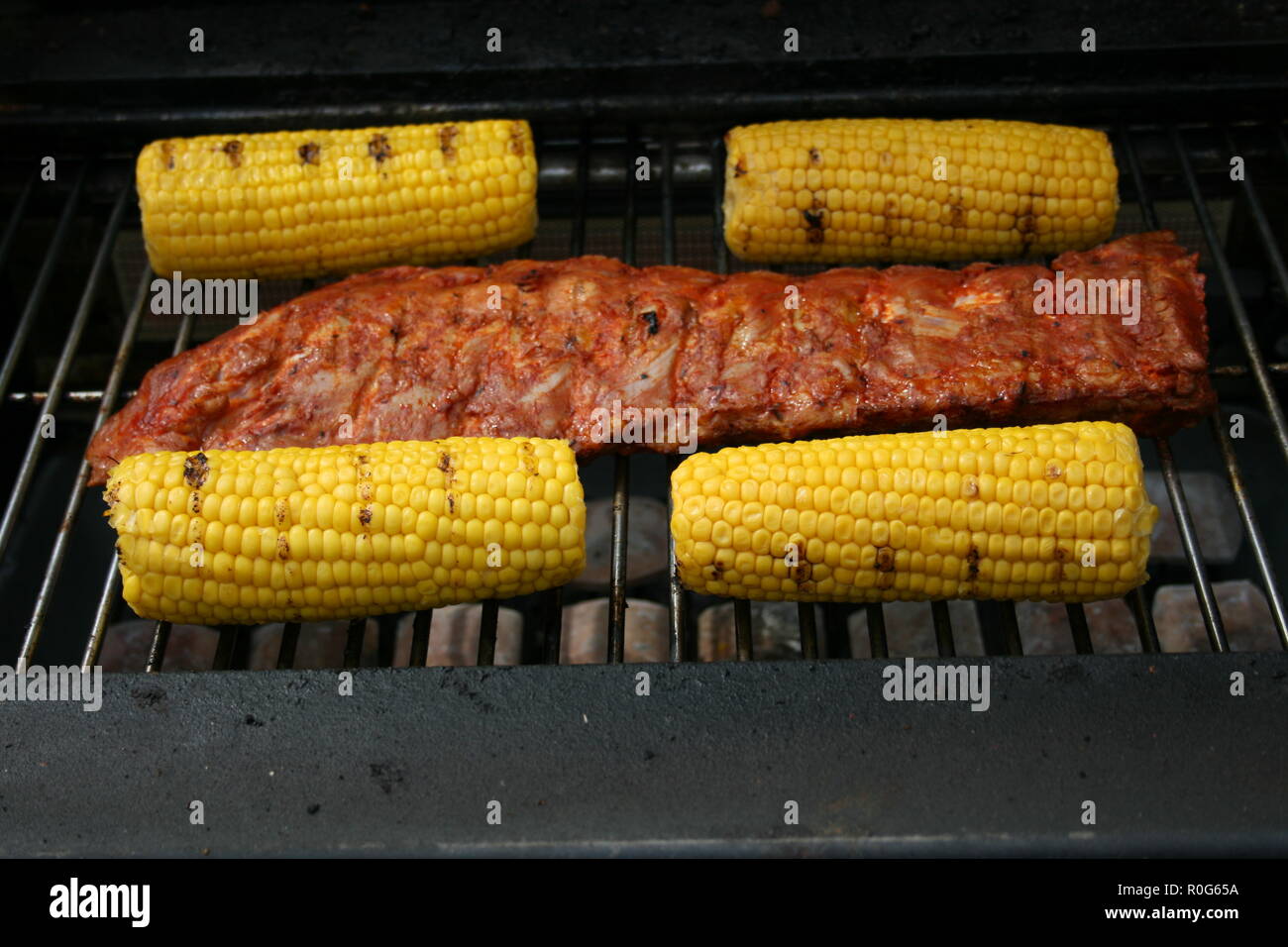 A large piece of meat and may four-piston on a gas Grill Stock Photo