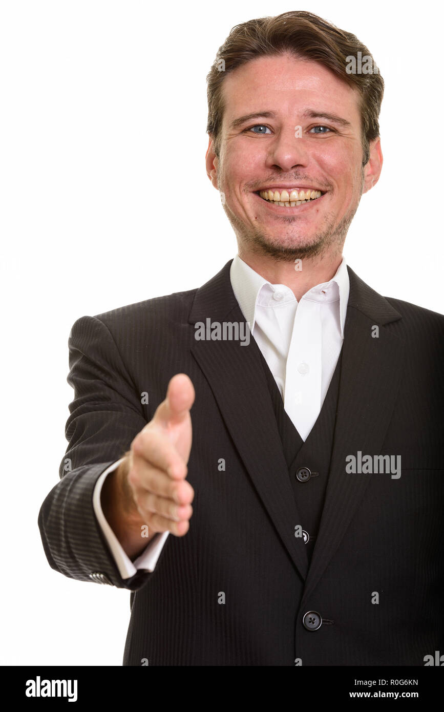 Happy Caucasian businessman giving handshake while smiling Stock Photo