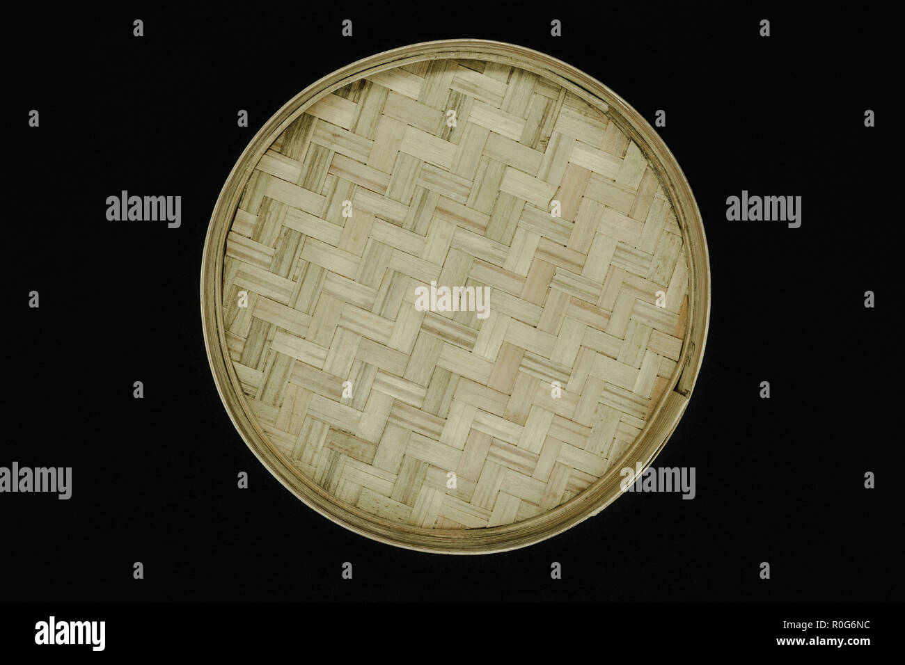 Round bamboo plate isolated on black background Stock Photo