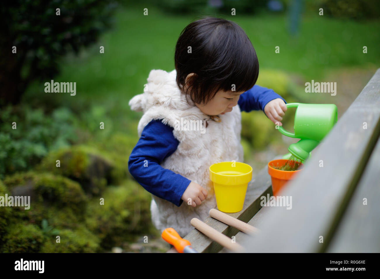 baby girl pretend play in garden Stock Photo Alamy