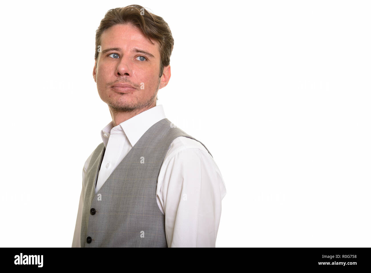 Handsome formal Caucasian man wearing vest while thinking Stock Photo
