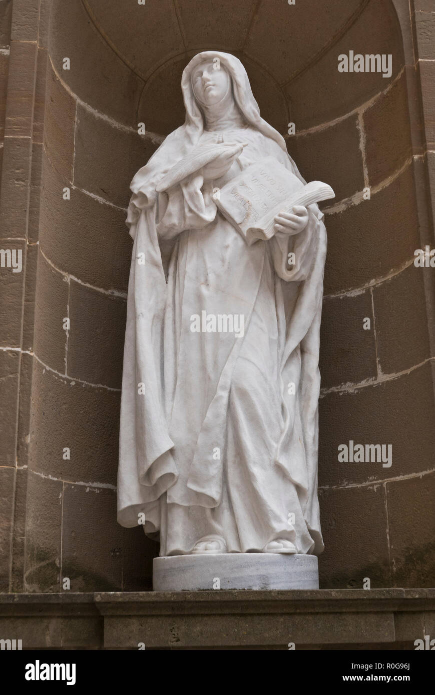 A religious statue in cloister in the courtyard at the Benedictine abbey Santa Maria de Montserrat, Barcelona, Spain Stock Photo
