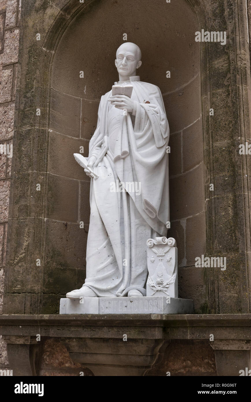 A religious statue in a cloister in the courtyard at the Benedictine abbey Santa Maria de Montserrat, Barcelona, Spain Stock Photo