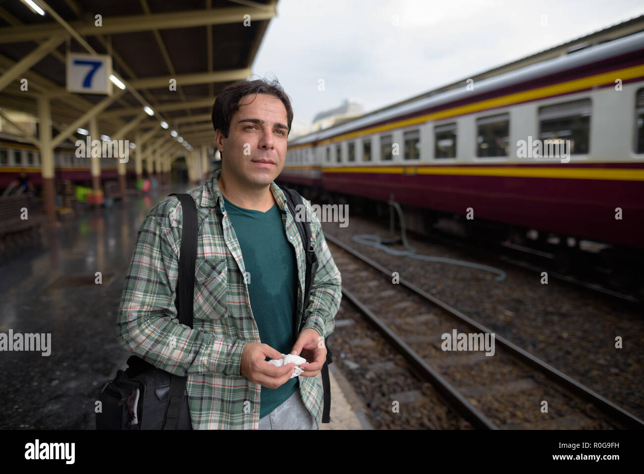 Handsome Persian tourist man at the railway station in Bangkok Stock Photo
