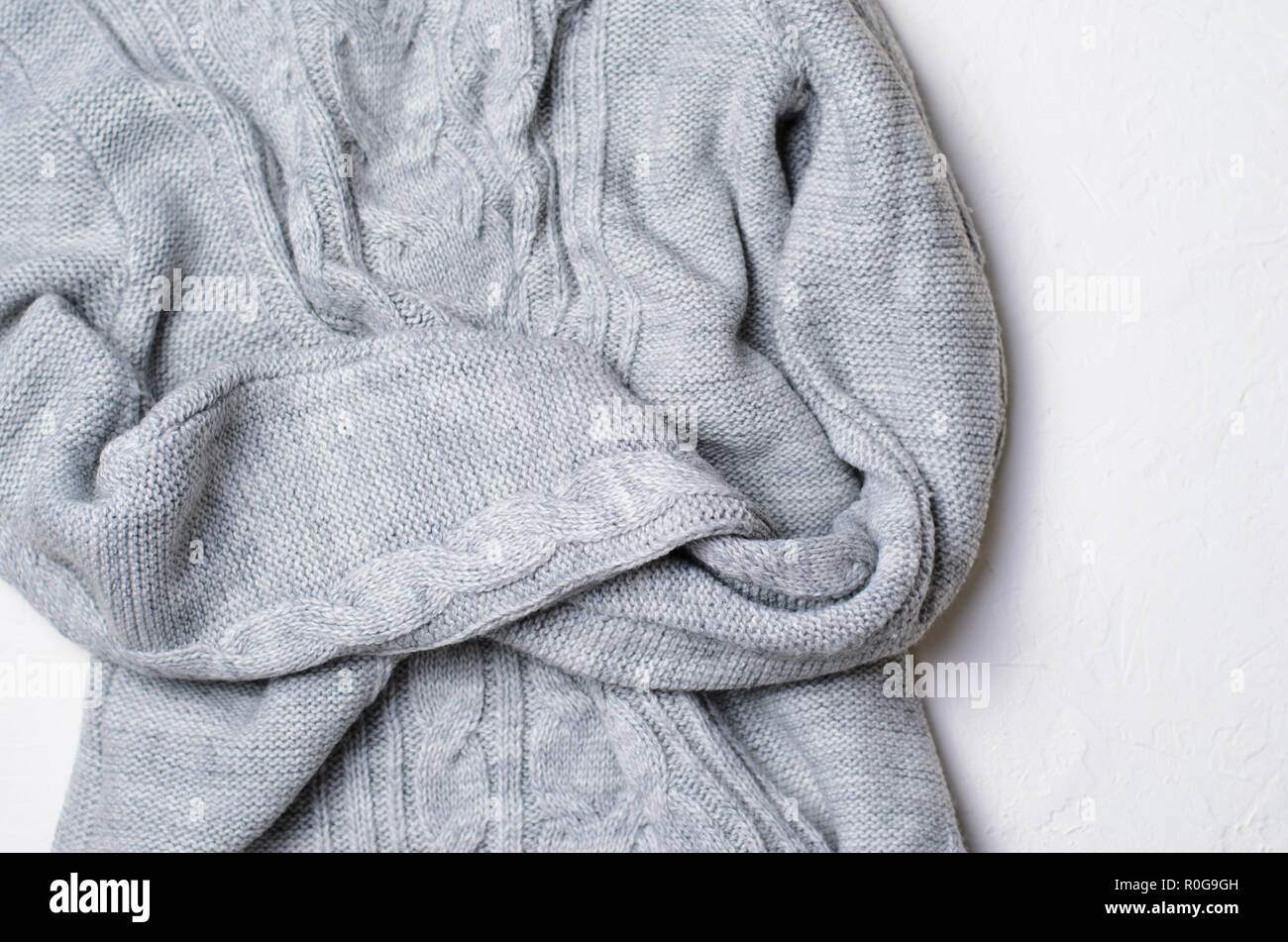 Grey Sweater on White Background, Knitted Winter Clothing, Top View Stock Photo