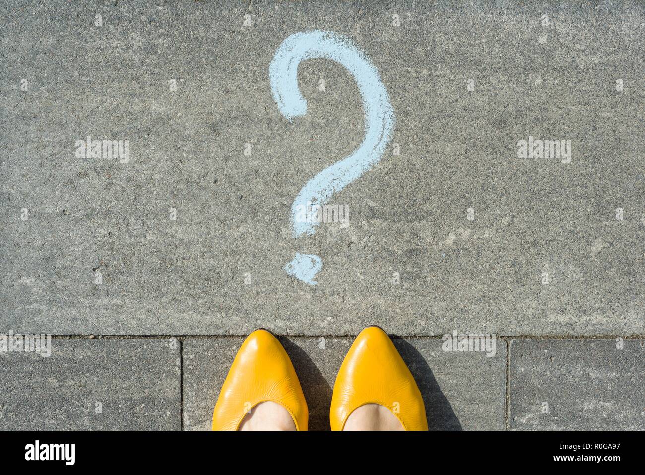 Woman feet with question mark in front of her legs painted on the