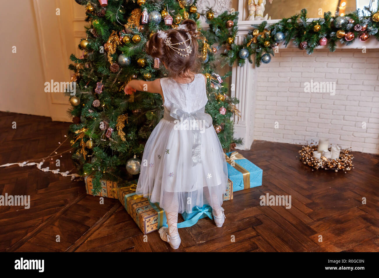 Little Girl Decorating Christmas Tree On Christmas Eve At