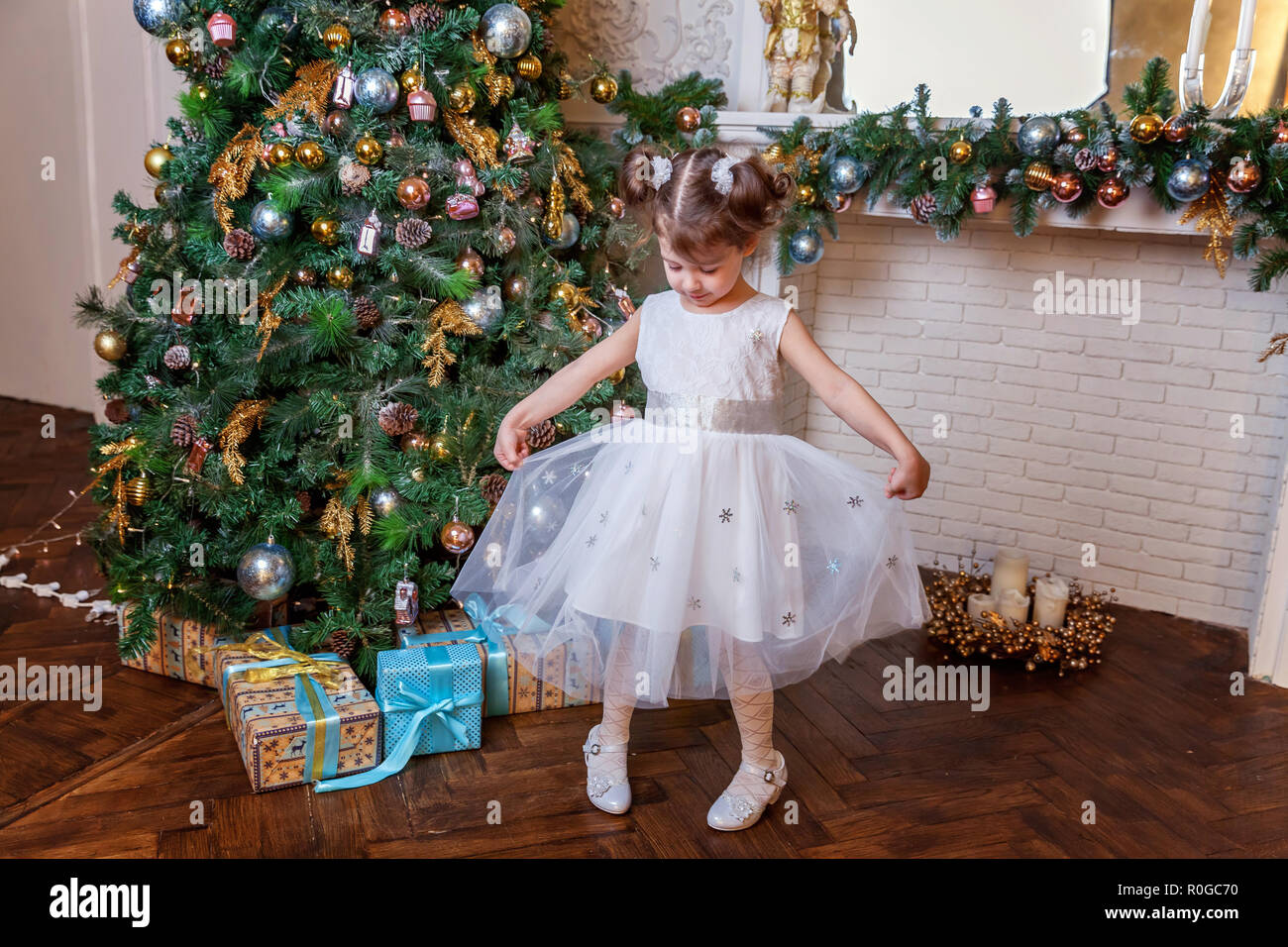 Little Girl Decorating Christmas Tree On Christmas Eve At