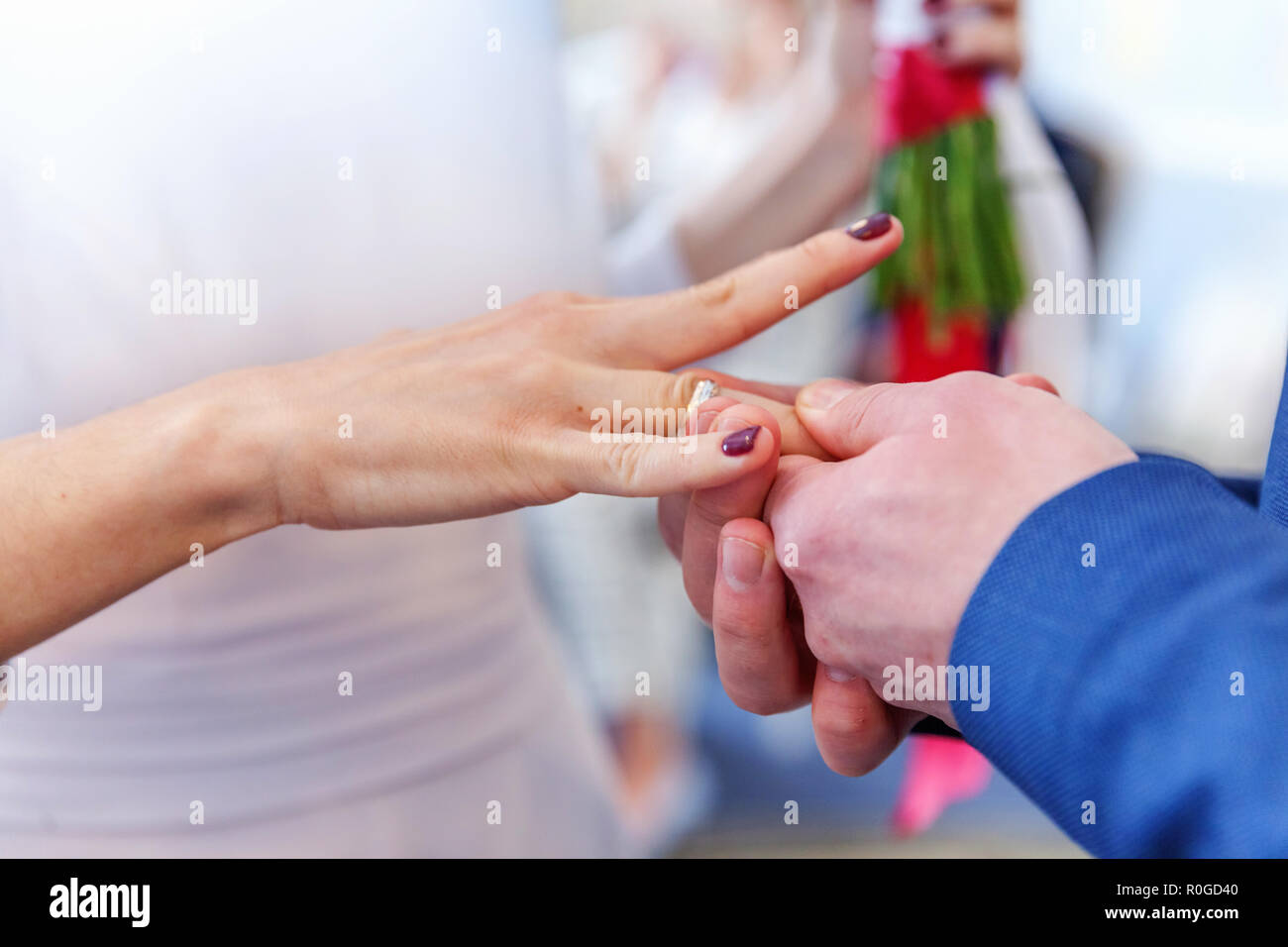 Bride and groom marriage hands with wedding rings. Groom hand putting wedding ring on bride finger. Declaration of love, spring. Wedding card greeting. Wedding day moments ceremony details Stock Photo