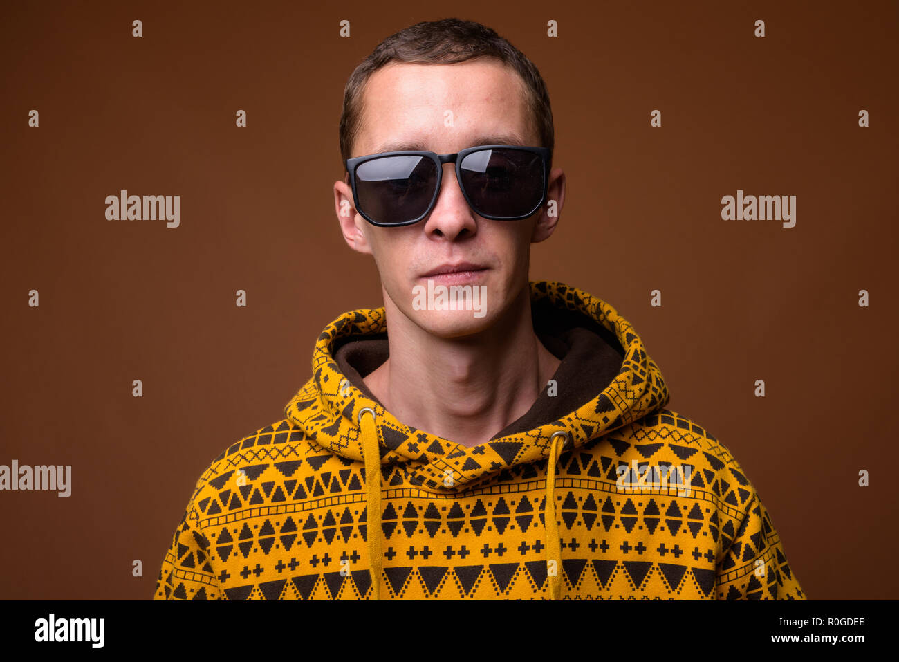 Studio shot of young man against brown background Stock Photo