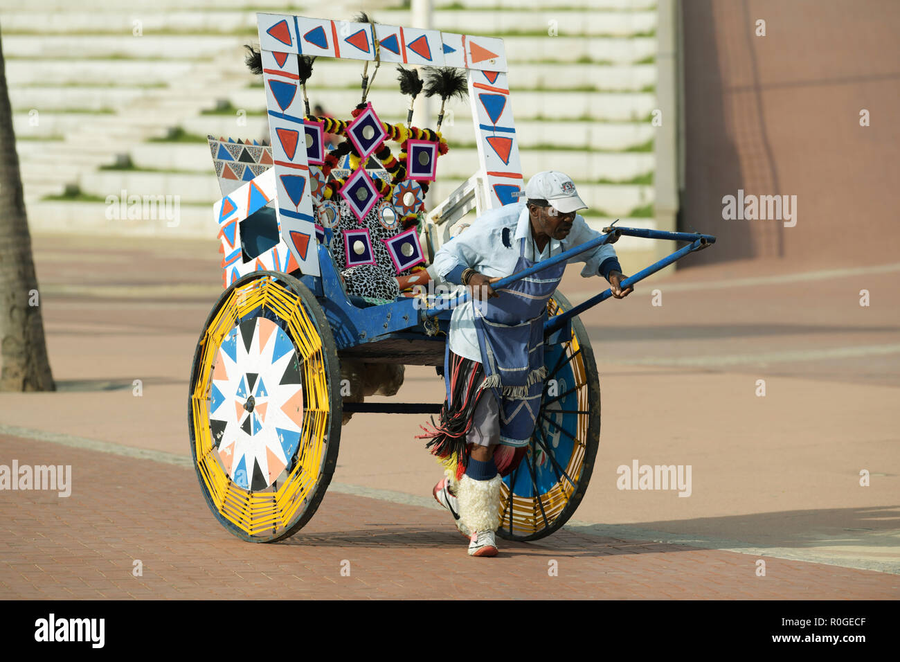 Durban, KwaZulu-Natal, South Africa, single adult Zulu man pulling his Rickshaw on Golden Mile beachfront to start his work of doing tourist rides Stock Photo