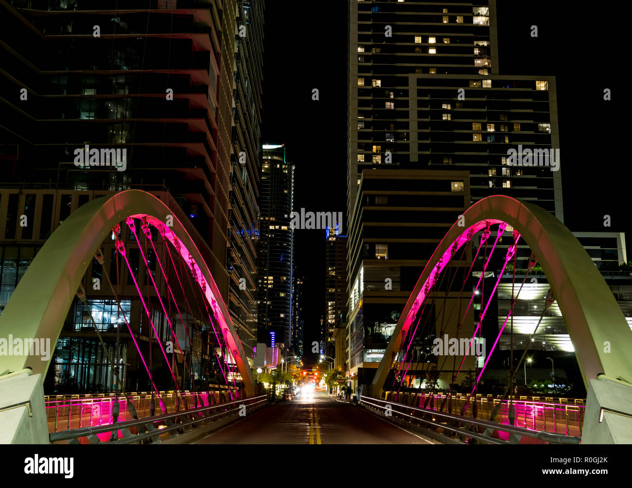 A new suspension bridge spanning shoal creek on 2nd street of downtown Austin, Texas flashes multiple bright colors at night. Stock Photo