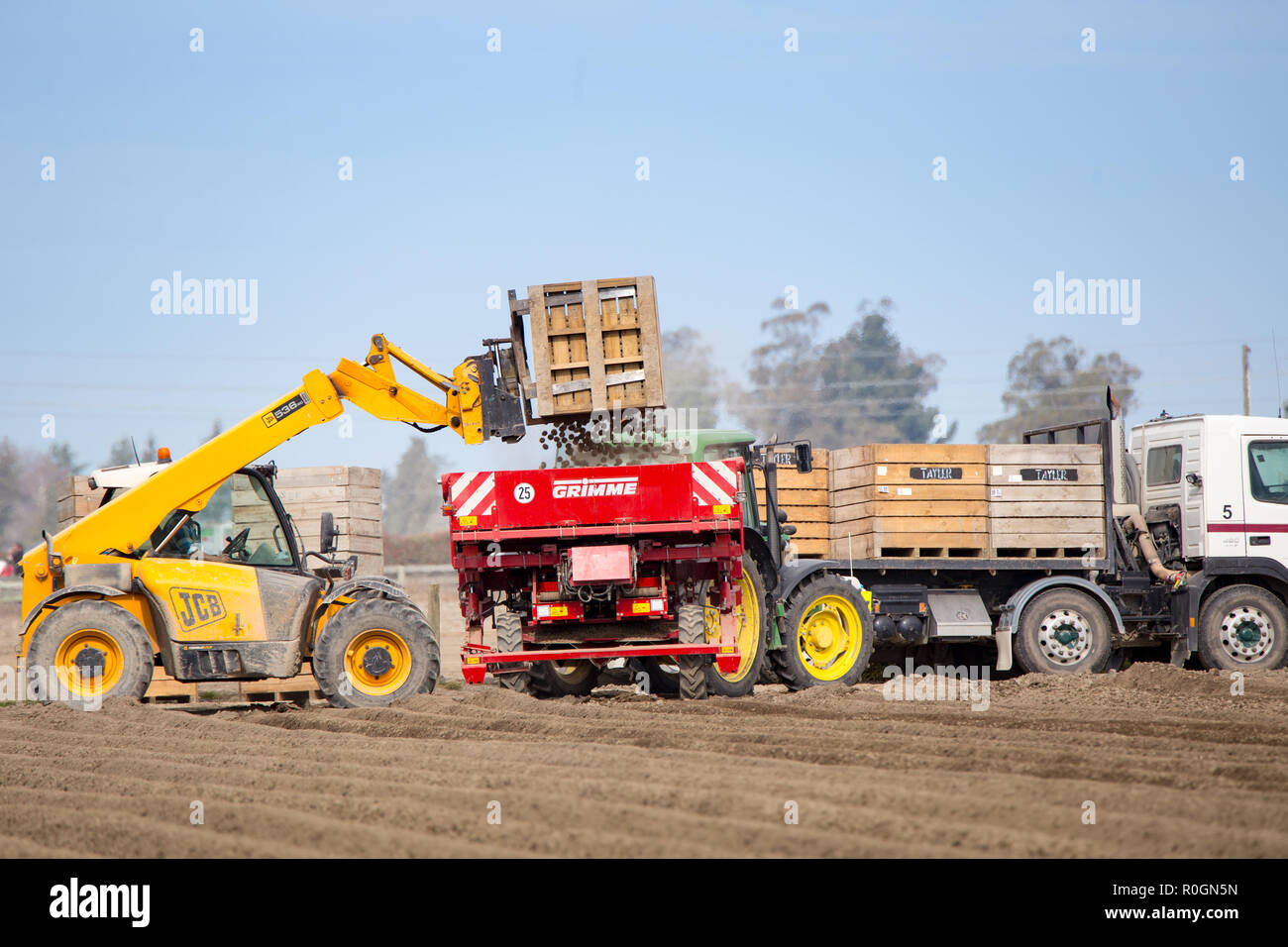 Temuka, Canterbury, New Zealand - September 14 2018: A seeder is refilled with potatoes to be sown in a freshly ploughed field Stock Photo