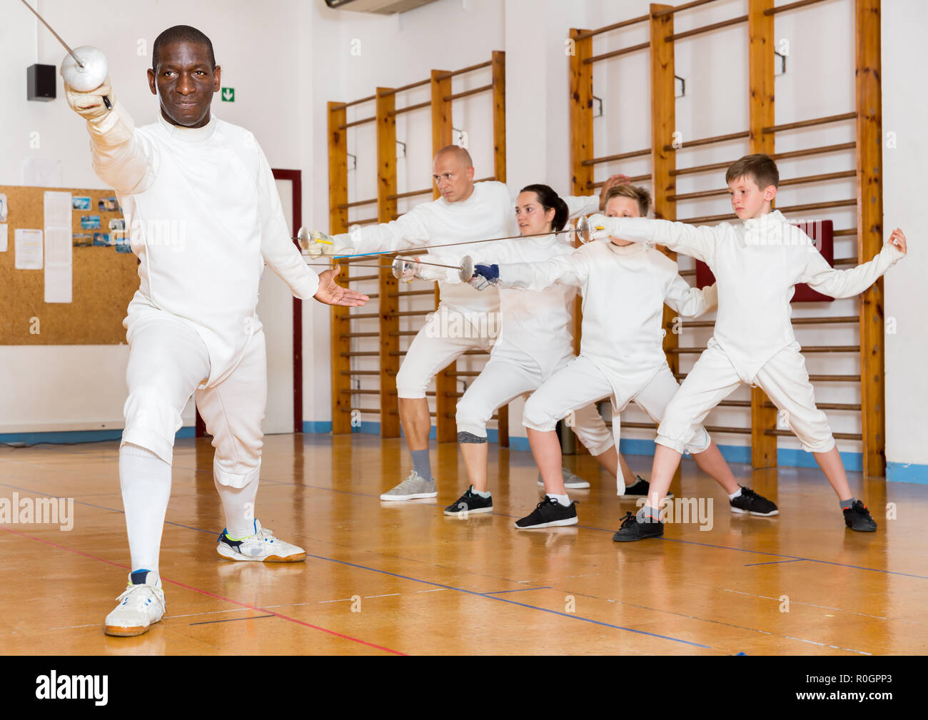 African American man wearing fencing uniform practicing with foil at a