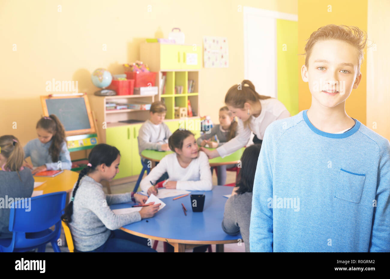 Portrait of ordinary schoolboy and children drawing in classroom Stock ...