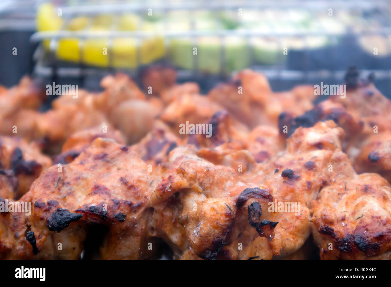 Skewers with roasted chiken meat and vegetables on the hot grill closeup, weekend barbecue Stock Photo