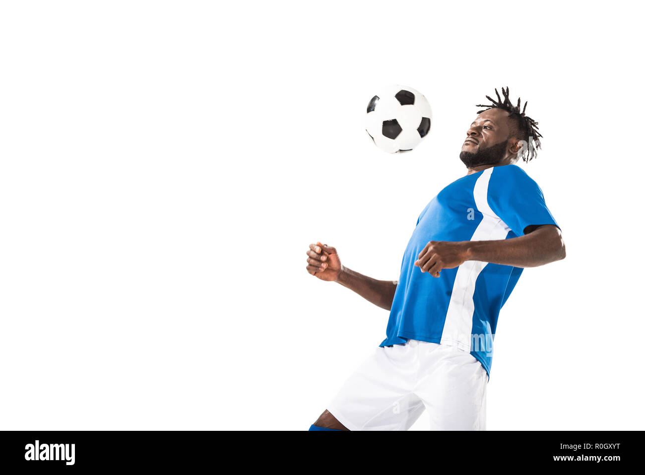 athletic young african american soccer player hitting ball with chest isolated on white Stock Photo