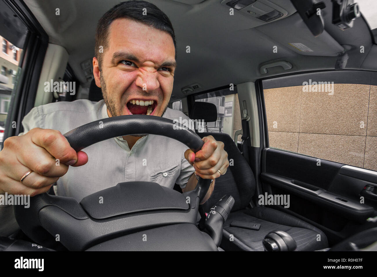 Emotional person. The driver of the car screams at someone in the traffic jam. Concept hysterics and broken car Stock Photo