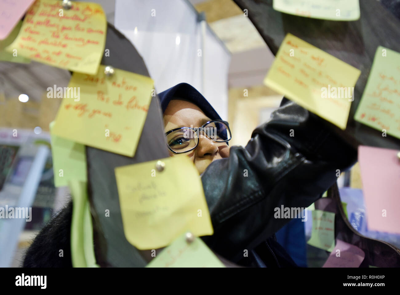 North African woman sticking Post It suggestions for United Nations Climate Change Conference Marrakesh  at the MED COP 2016 Morocco Stock Photo