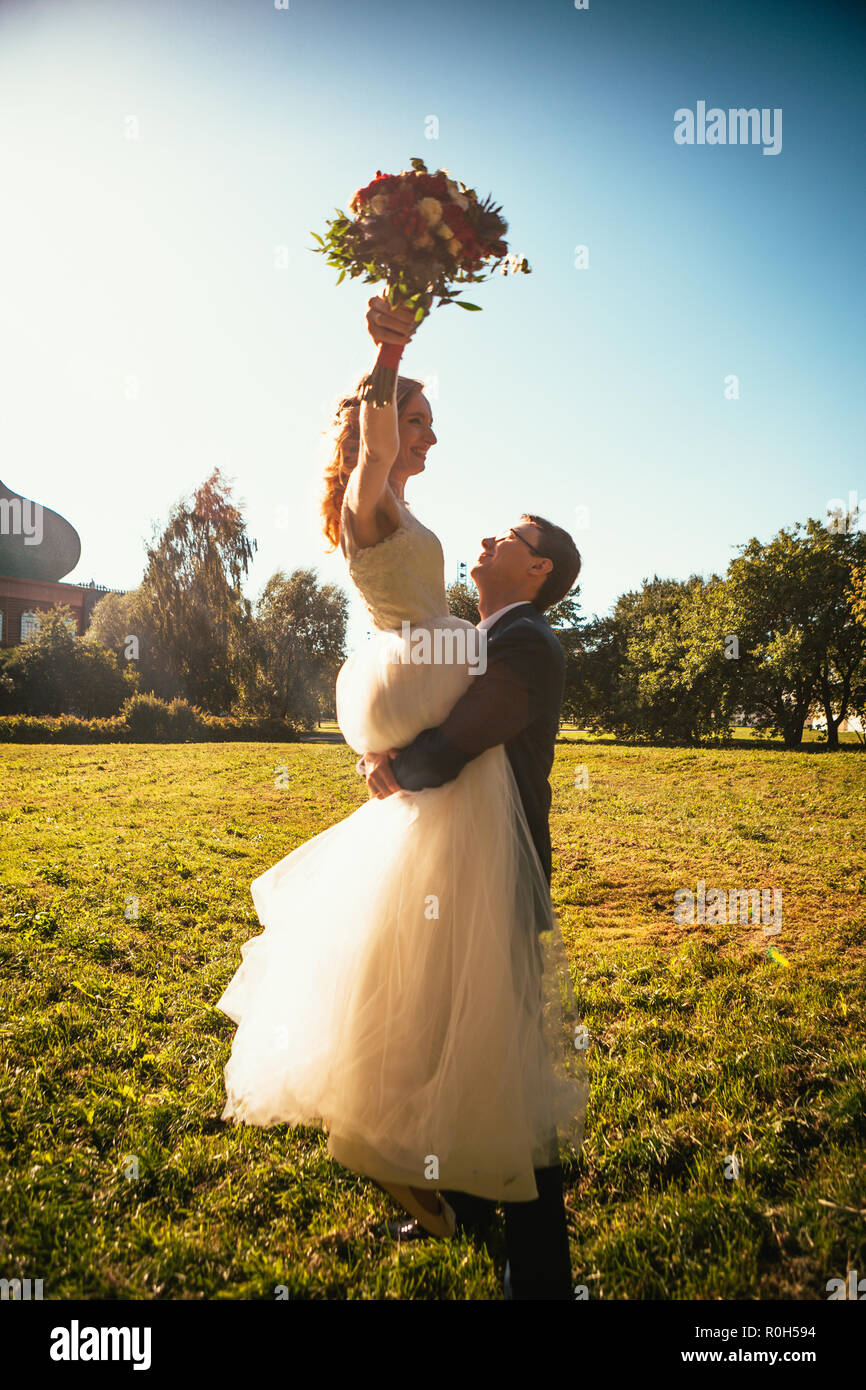 Dancing young bride and groom sunlight background Stock Photo - Alamy