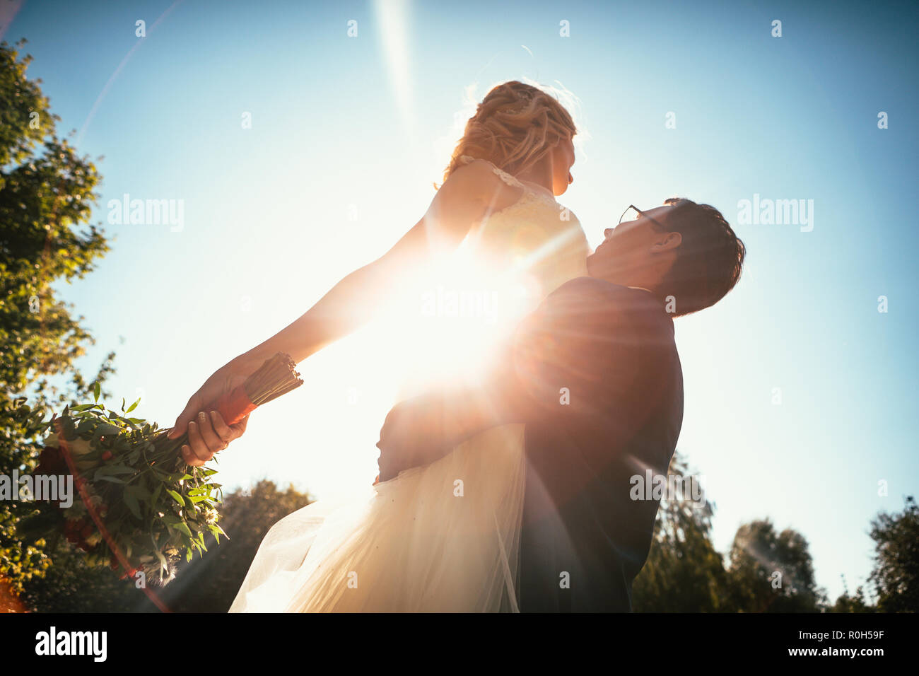Dancing young bride and groom sunlight background Stock Photo - Alamy