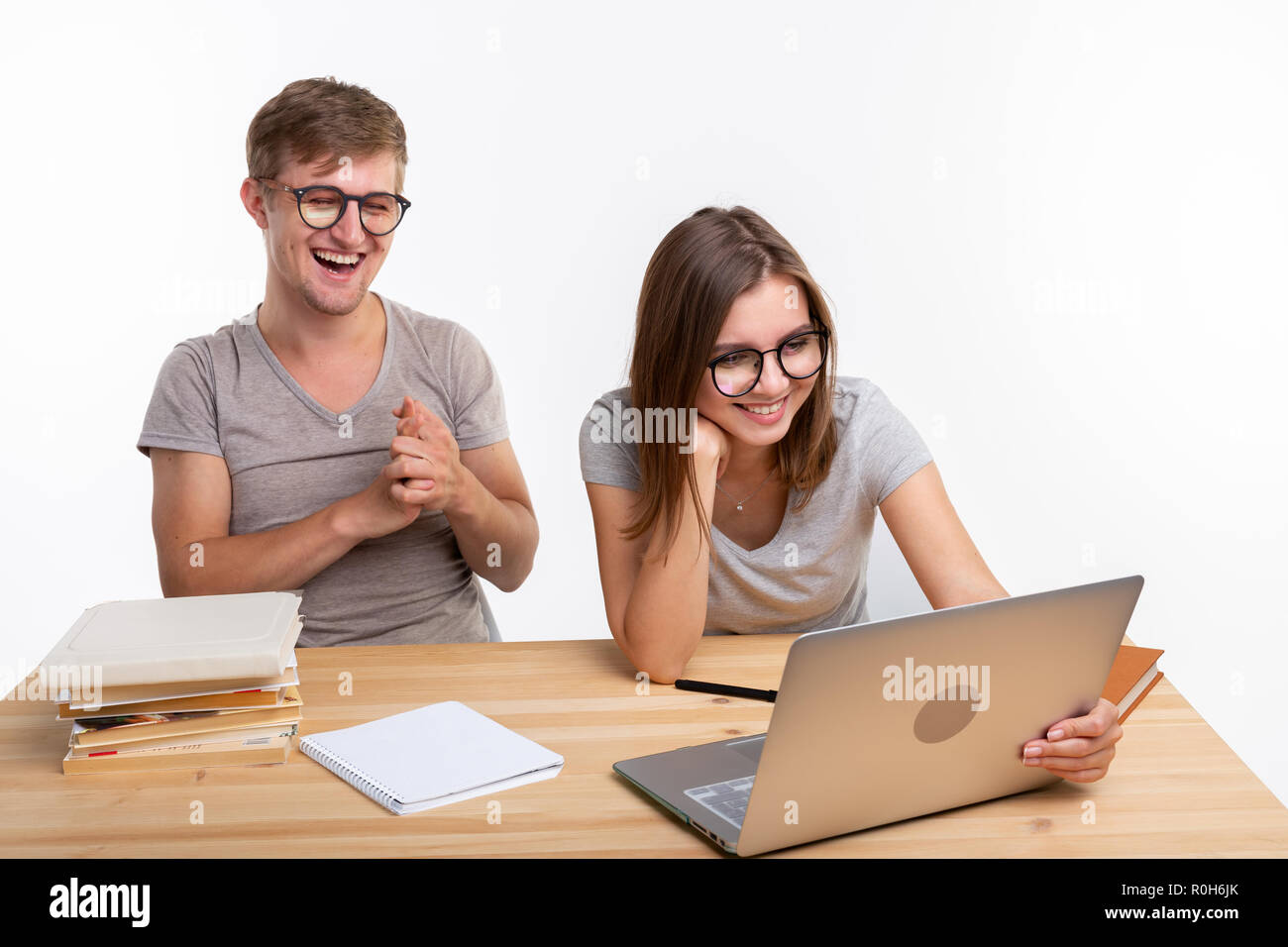 People and education concept - Two laughing students sitting at a table Stock Photo