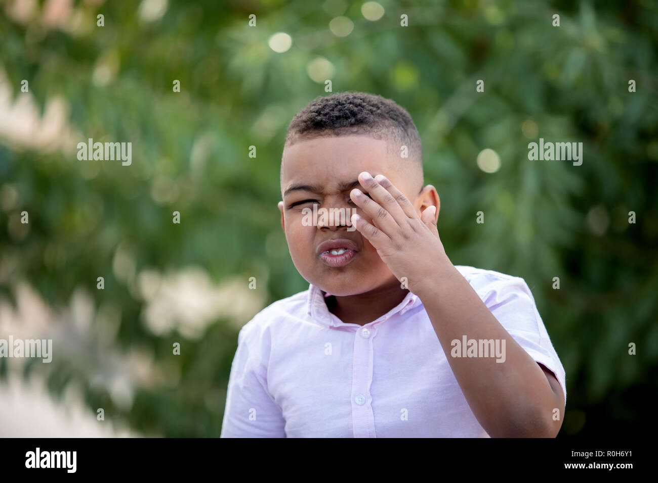 Happy child covering his eye in the park Stock Photo Alamy