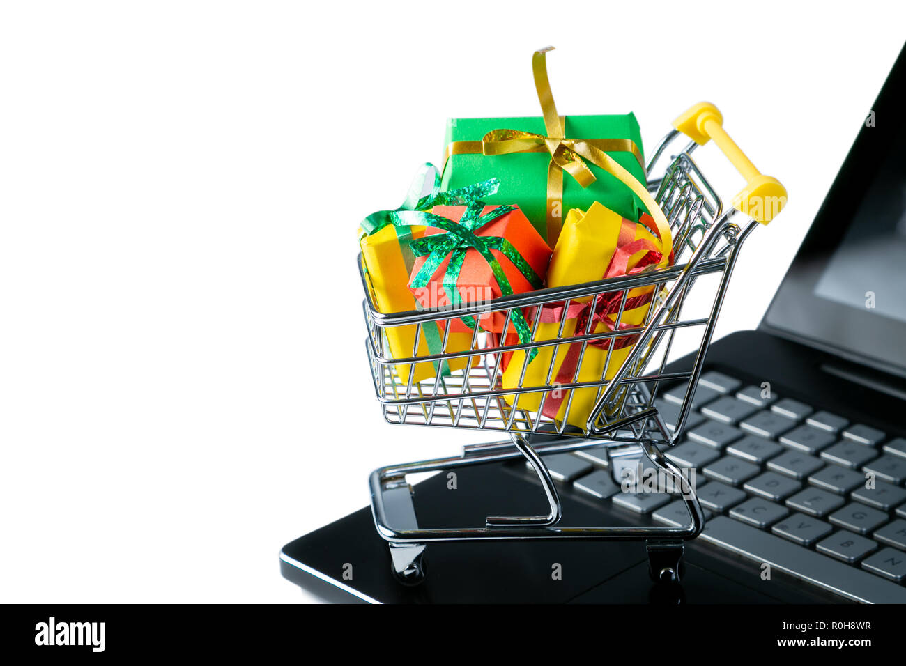 Ciber monday concept - trolley cart with christmas presents on notebook Stock Photo