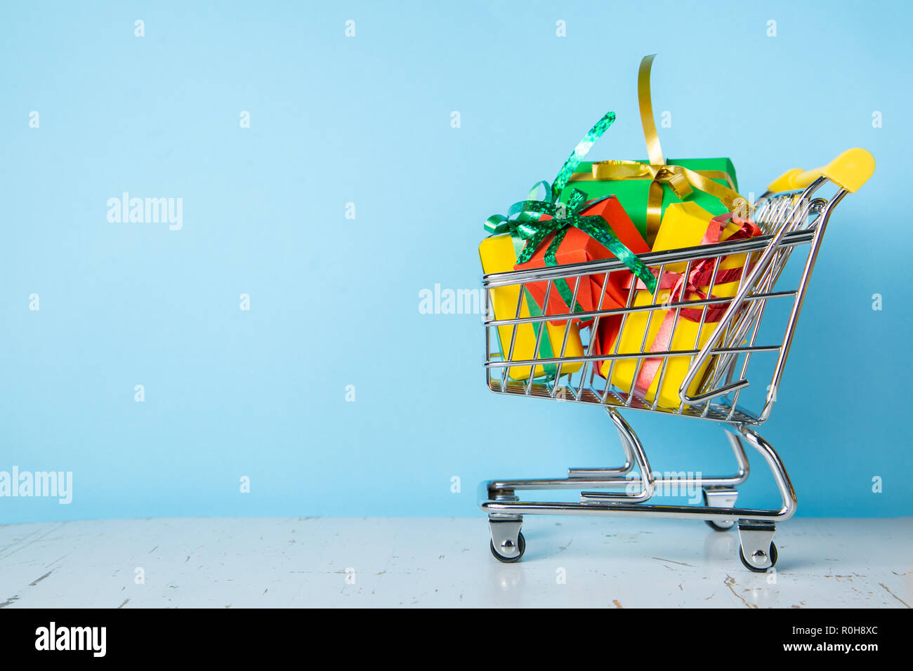 Ciber monday concept - trolley cart with christmas presents, blue background Stock Photo