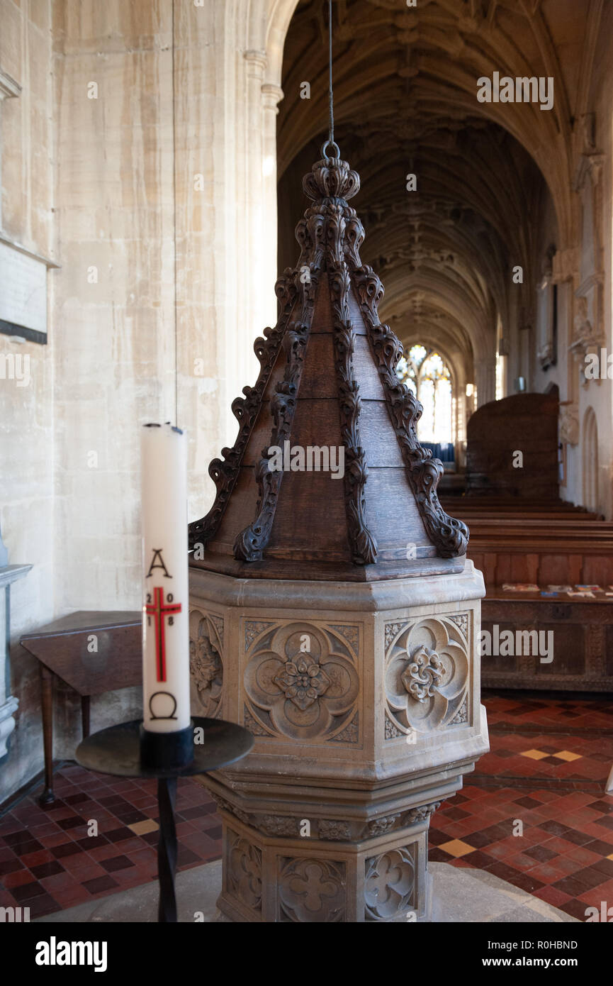 The 19th century font and Paschal Candle at the Church of St Mary the Virgin, Steeple Ashton, Wiltshire, UK. Stock Photo