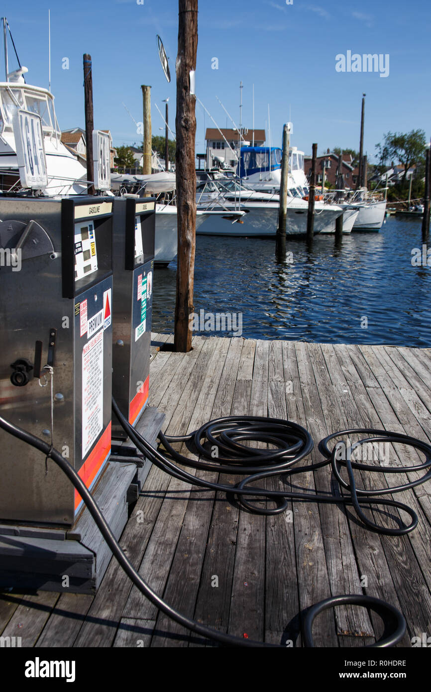 Two fuel pumps on an old wooden dock with different types of boats in the background. This photo is availble for commercial use provided that any trad Stock Photo