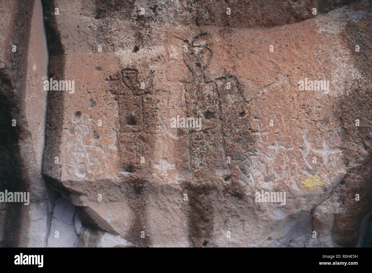 Native American petroglyphs of human figures, Tsankawi mesa cliff-dwellings, New Mexico. Photograph Stock Photo