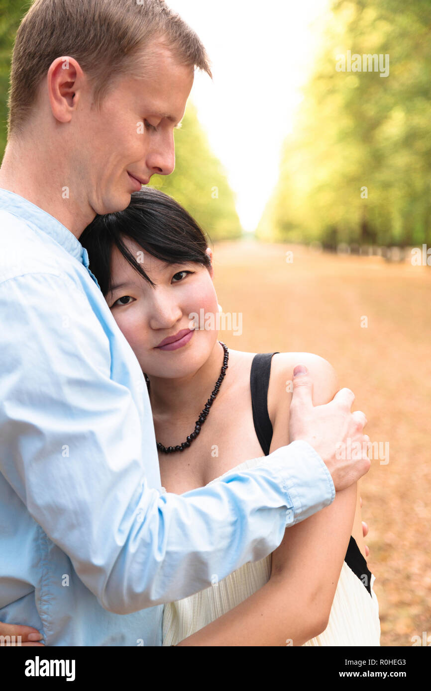 https://c8.alamy.com/comp/R0HEG3/romantic-international-couple-in-beautiful-park-hugging-each-other-R0HEG3.jpg