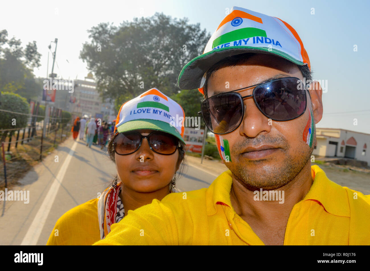 Selective focus on man. Cricket fans with painted face in Indian tricolor. Happy young loving couple looking at camera. Capturing bright cheerful mome Stock Photo