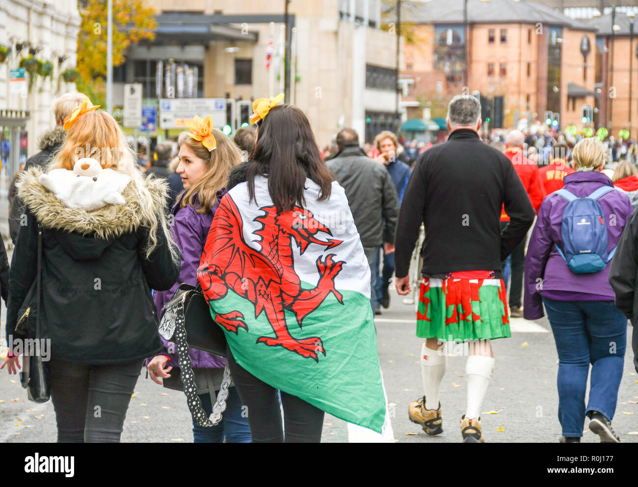 CARDIFF, WALES - NOVEMBER 2018: Female supporter with a Welsh flag, the 'Red Dragon', draped over her shoulders in Cardiff city centre on the day of a Stock Photo