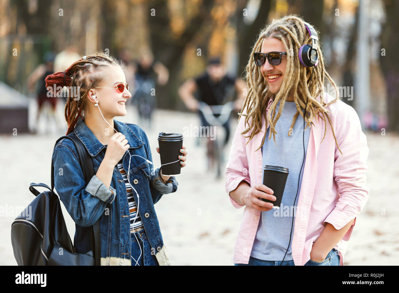 Two hipster best friends with dreads wearing headphones and glasses