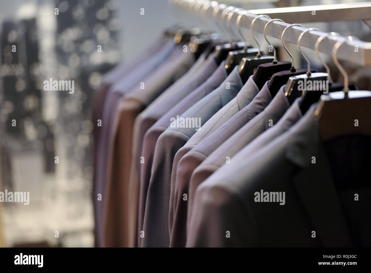 Row of suits on a hanger in store for sale and empty space for text Stock Photo